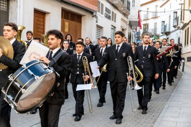 Castro del Rio, Cordoba - İspanya - 03-24-2024: Semana Santa Easter alayında pirinç ve perküsyon enstrümanları çalan müzisyenler eşliğinde bir yürüyüş bandosu sahne aldı.