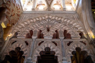 Cordoba, Cordoba - İspanya - 04-08-2024: Mezquita-Katedral de Cordoba 'daki karmaşık şekilde oyulmuş ve dekore edilmiş kemerlerin ayrıntılı bir görüntüsü.