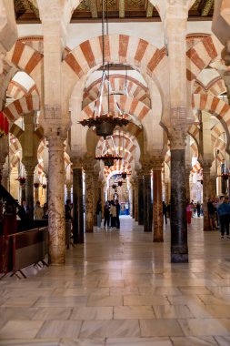 Cordoba, Cordoba - İspanya - 04-08-2024: Mezquita-Katedral de Cordoba 'nın merkez salonu büyük kemerler ve zarif avizelerle donatılmış.