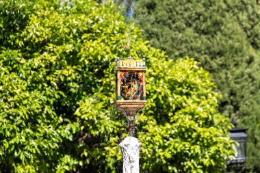 Dekoratif bir çeşme başı kaynayan su yayar, sanatsal gösteriler yapar ve canlandırıcı bir ortam yaratır..