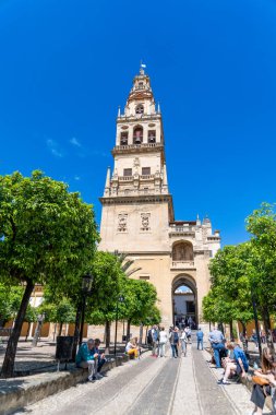 Cordoba, Cordoba - İspanya - 04-08-2024: Mezquita-Katedrali 'nin etrafı ziyaretçiler ve portakal ağaçlarıyla çevrili çan kulesi.