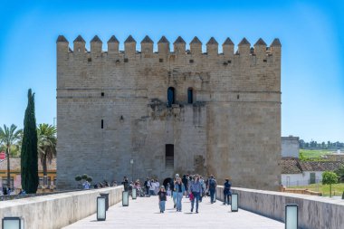 Cordoba, Cordoba - İspanya - 04-08-2024: Roma Köprüsü 'nde turistlerin yürüdüğü ortaçağ savunma kulesi Torre de la Calahorra.