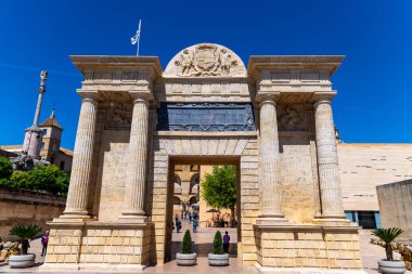Cordoba, Cordoba - İspanya - 04-08-2024: The Puerta del Puente, temiz bir gökyüzü ve tarihi mimari tarafından çerçevelenmiş neoklasik tarzda bir geçit.