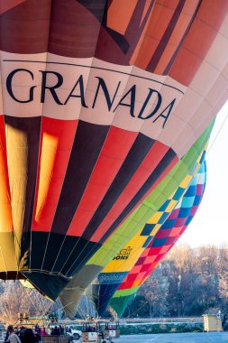 Guadix, Granada - Spain - 01-24-2024: Close-up of a large red and colorful balloon with the text Granada. Other colorful balloons are visible in the background. clipart