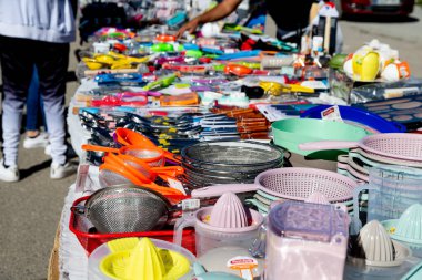 Guadix, Granada - İspanya - 01-24-2024: Guadix 'te plastik kaplar, turunçgil sıkacakları ve süzgeçlerin yer aldığı bir pazar yerinde renkli ev eşyalarının yakın çekimi.