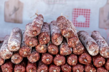 Havada kurutulmuş sosis çubuklarının yakın plan çekimi, pazara istiflenmiş, beyaz küf tabakası yaşlandığını gösteriyor..