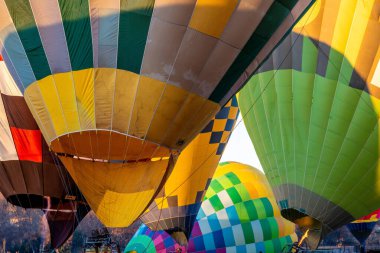 Sıcak havayla dolu canlı sıcak hava balonlarının yakın plan çekimi, sarı-yeşil kareli balon, canlı bir sahne yaratır.