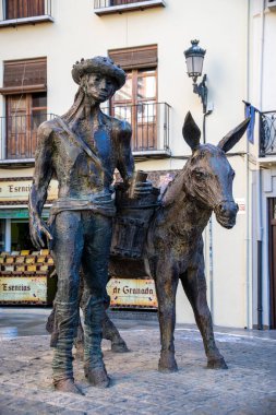Granada, Granada - İspanya - 02-03-2024: Granada 'da işlek bir sokakta metal eşeği olan bir adamın heykeli.