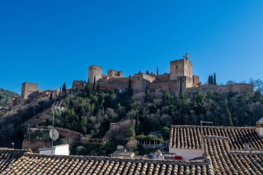Granada, Granada - İspanya - 02-03-2024: Granada 'nın Alhambra' sı mavi gökyüzüne karşı kulelerini gösteren alçak bir perspektiften yakalandı.