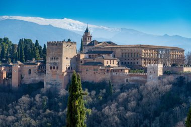 Granada, Granada - İspanya - 02-03-2024: Granada 'daki Alhambra görkemli bir şekilde karlı Sierra Nevada arkaplanlı bir tepede oturuyor.