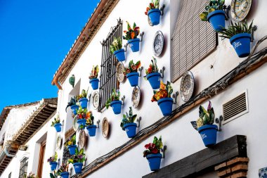 Granada, Granada - İspanya - 02-03-2024: Geleneksel Endülüs evi cephesi mavi saksılar ve dekoratif seramik fayanslarla süslenmiş.