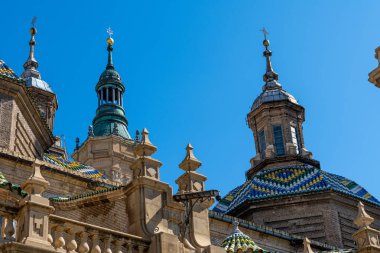 Zaragoza 'daki Plaza del Pilar' ın manzarasında, küresel bir heykel ve San Juan de los Panetes 'in eğik kilisesi sergileniyor..