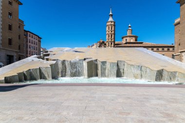 İspanya 'nın Zaragoza kentindeki Fuente de la Hispanidad' ın geniş açılı manzarası, San Juan de los Panetes kulesi ve çağlayan su hatları.