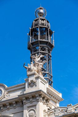 Valencia, İspanya 'daki Oficina de Correos' un sanat kulesi. Heykeller, dekoratif unsurlar ve mavi gökyüzü arka planı..