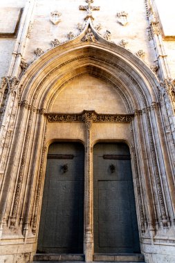 Valencia Katedrali 'nde iki kanatlı dev bir geçit çiçek ve figüratif taş işçiliği, metal halkalı büyük kapılar ve kabartmalar..