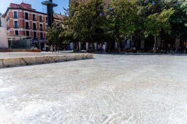 Saragossa, Saragossa - İspanya - 09-10-2021: Güneşli bir günde İspanya 'nın Zaragoza kentinde mermer, ağaç ve Tibur Oteli' nin temiz sularıyla çevrili düz bir çeşme.