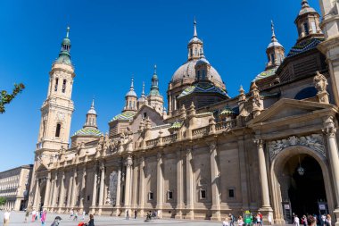 Saragossa, Saragossa - İspanya - 09-10-2021: Zaragoza 'daki Bazilika del Pilar' ın yan görünüşü, heykeller, kubbeler ve mavi gökyüzüne karşı karmaşık barok ayrıntılarıyla süslenmiş.