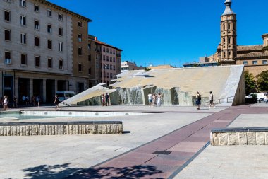 Saragossa, Saragossa - İspanya - 09-10-2021: Modern su heykeli, düz havuz, yansımalar ve arka planda San Juan de los Panetes kulesi ile Plaza del Pilar manzarası.