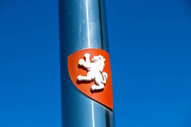 Saragossa, Saragossa - Spain - 09-10-2021: Coat of arms with a white lion on a red shield, mounted on a polished silver post, against a clear blue sky with visible details. clipart