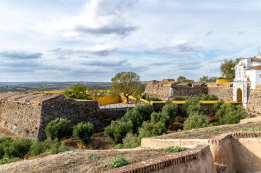 Fuerte de Santa Luzia 'nın panoramik manzarası. Sarı duvarlar, beyaz yapılar, zeytin ağaçları ve bulutlu bir gökyüzünün altındaki görüş alanları..