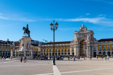 Lissabon, Lisboa - Portugal - 09-30-2024: Praca do Comercio in Lisbon shows King Jose I statue at center, with Rua Augusta Arch and yellow historic buildings under a clear blue sky. clipart