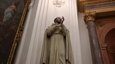 Cordoba, Cordoba - İspanya - 04-08-2024: Mezquita 'daki Saint Pedro Nolasco heykelinin yakın çekimi, altın ayrıntılar, mermer taban ve sakin, düşünceli ifade gösteriliyor.