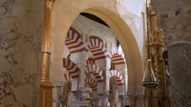 Cordoba, Cordoba - İspanya - 04-08-2024: Mezquita 'nın kırmızı-beyaz kemerlerini çerçeveleyen parlak bir kemer vasıtasıyla tarihi zerafet ve simetriyi yakalayın.