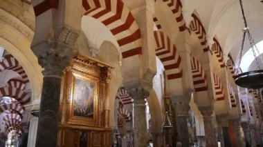 Cordoba, Cordoba - İspanya - 04-08-2024: Altın çerçeveli Hristiyan sanat eserlerinden Mezquita 'daki Fas koridoruna Pan, büyük kapılı bir kapıyla sona erdi.