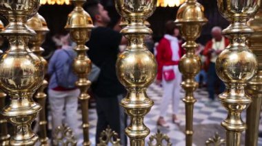 Cordoba, Cordoba - İspanya - 04-08-2024: Mezquita 'daki parlak altın çitin yakın çekim tavası, geçişi ve koroyu birbirinden ayırıyor, arka planda insanlar görülüyor.