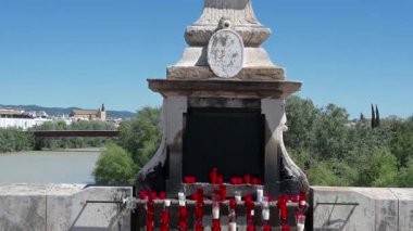 Roma Köprüsü 'ndeki Başmelek Raphael heykelinin tepesi, kırmızı ve beyaz mumlarla başlıyor, mavi gökyüzü ve şehir manzarasıyla bitiyor..
