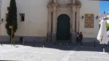 Cordoba, Cordoba - İspanya - 04-09-2024: Süslü girişi, Berberi pencereleri, çan kulesi, parlak mavi gökyüzü altındaki altın mozaik beyaz-kırmızı kilise cephesi.