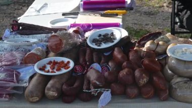 Denia, Alicante - İspanya - 12-01-2024: Pazar tezgahı, her üründe tadımlık küçük tabaklar bulunan çeşitli sosis ve peynir spesiyalleri sunuyor; soldan sağa doğru pan.