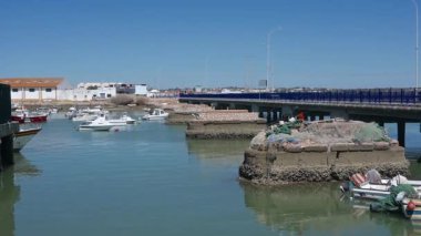 Cristina Adası, Huelva - Portekiz - 09-09-2024: Balıkçı tekneleri Cristina Adası 'ndaki bir köprünün yakınında demirli. Beton platformlar balıkçı ağları barındırır ve arka planda sanayi binaları görünür..