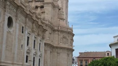 La Giralda 'nın Sevilla Katedralleri' nin ön cephesinde yukarı doğru yanaş, mavi-beyaz gökyüzünün altında çan ve bronz El Giraldillo heykelini göster.