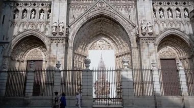 Toledo, Toledo - İspanya - 06-05-2024: Mavi gökyüzüne karşı mimari ve heykel ayrıntılarını gösteren Toledo Katedralleri 'nin güneşli cephesine yukarıdan bakan tava.