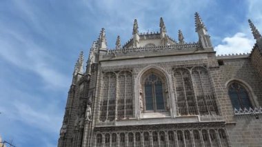 San Juan de los Reyes Manastırı cephesi. Heykel ve mimari detaylar, süslü giriş ve parlak mavi-beyaz gökyüzü..