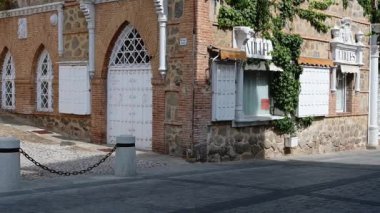 Toledo, Toledo - İspanya - 06-05-2024: Kulesi, Filistin bayrağı, tuğla kemerleri, beyaz kapılar ve pencereler, sarmaşık ve pencerelerinin üzerinde antika işareti olan tarihi bir bina.