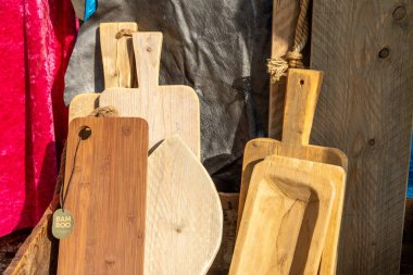 Farklı şekil ve boyutlarda ahşap kesme tahtaları koleksiyonu, kırsal ahşap bir arka plana karşı dizilmiş bambu tahtası da dahil..