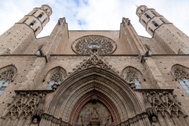 Santa Maria del Mar 'ın Gotik cephesi iki simetrik kulesi, büyük bir gül penceresi ve bulutlu bir gökyüzüne karşı sivri kemerli bir girişi olan.