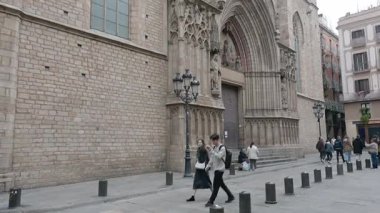 Barselona, Katalonya - İspanya - 01-06-2025: Santa Maria del Mar 'a sokak seviyesinde bir bakış açısı, Gotik cephesini, kemerli girişini, ikiz kuleleri ve ayrıntılı taş oymalarını gözler önüne sermek üzere yukarı doğru hareket ediyor.