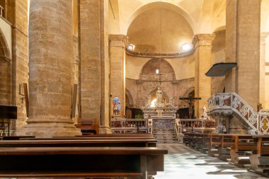 Alghero, Sardinia - İtalya - 02-13-2025: İçi taş sütunlar, kemerler ve kubbelerle dolu katedral. Heykellerle süslü sunaklar, mermer korkuluklar, kürsü ve kareli zemin üzerindeki banklar..