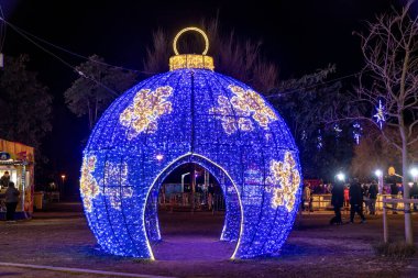 Barselona, Katalonya - İspanya - 01-07-2025: Büyük, parlak mavi bir Noel süsü ve altın kar tanesi desenleri bir gezinti gösterisi olarak hizmet veriyor.