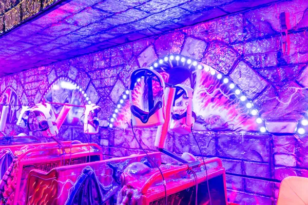 Barcelona, Katalonya - İspanya - 01-07-2025: Bir VR korku turunun yakın çekimi ve temalı koltuklara temalı, neon ışıklı, ürkütücü bir ortam..