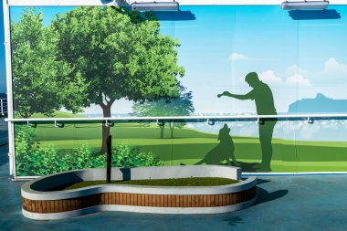 Barselona, Katalonya - İspanya - 01-10-2025: Grimaldi Cruise Roma feribotunda evcil tuvalet alanı suni çim, tırabzan ve bir köpekle parkta oynayan birini gösteren duvar resimleri.