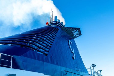 Barselona, Katalonya - İspanya - 01-10-2025: Grimaldi Cruise Roman feribot hunisinin gökyüzüne yükselen beyaz dumanlı yan görüntüsü, metal borular ve eğri havalandırma kapaklarını gösteriyor.