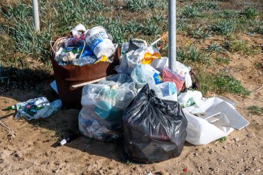 SArchittu - Sardinien - Italien - 03-02-2025: Plastik torbalar, şişeler ve yakındaki sahil arazisinden toplanan kumlu topraklara yerleştirilen diğer atıklar.