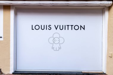 Porto Cervo - Sardinien - Italien - 02-22-2025: Louis Vuitton mağazası Porto Cervo, Sardinya 'da büyük beyaz bir panel, marka logosu ve merkezde basit bir çizgi sanat figürü sergileniyor.