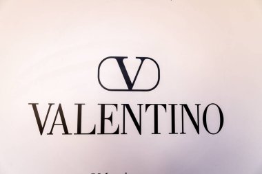 Porto Cervo - Sardinien - Italien - 02-22-2025: Beyaz zemin üzerinde stilize V sembolü bulunan siyah Valentino logosu, doğal ışık koşulları altında Porto Cervo, Sardinya 'da çekildi.