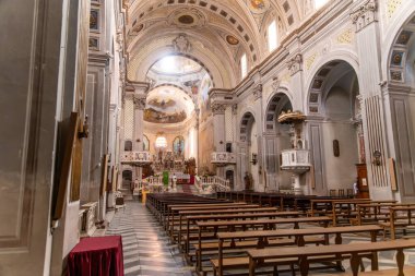 Bosa - Sardinien - Italien - 02-28-2025: Zengin dekore edilmiş bir barok kilisenin iç görünümü ahşap sıralar, yüksek tavan, süslü sunak, kemerli duvarlar ve dini tablolar.