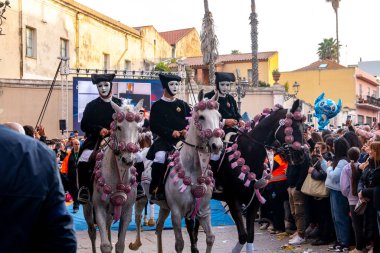 Oristano - Sardinien - Italien - 03-02-2025: Siyah kostümlü üç maskeli süvari ve süslü atlar Oristano 'da geleneksel renkli karnaval kutlamaları sırasında geçit töreni yapıyorlar.